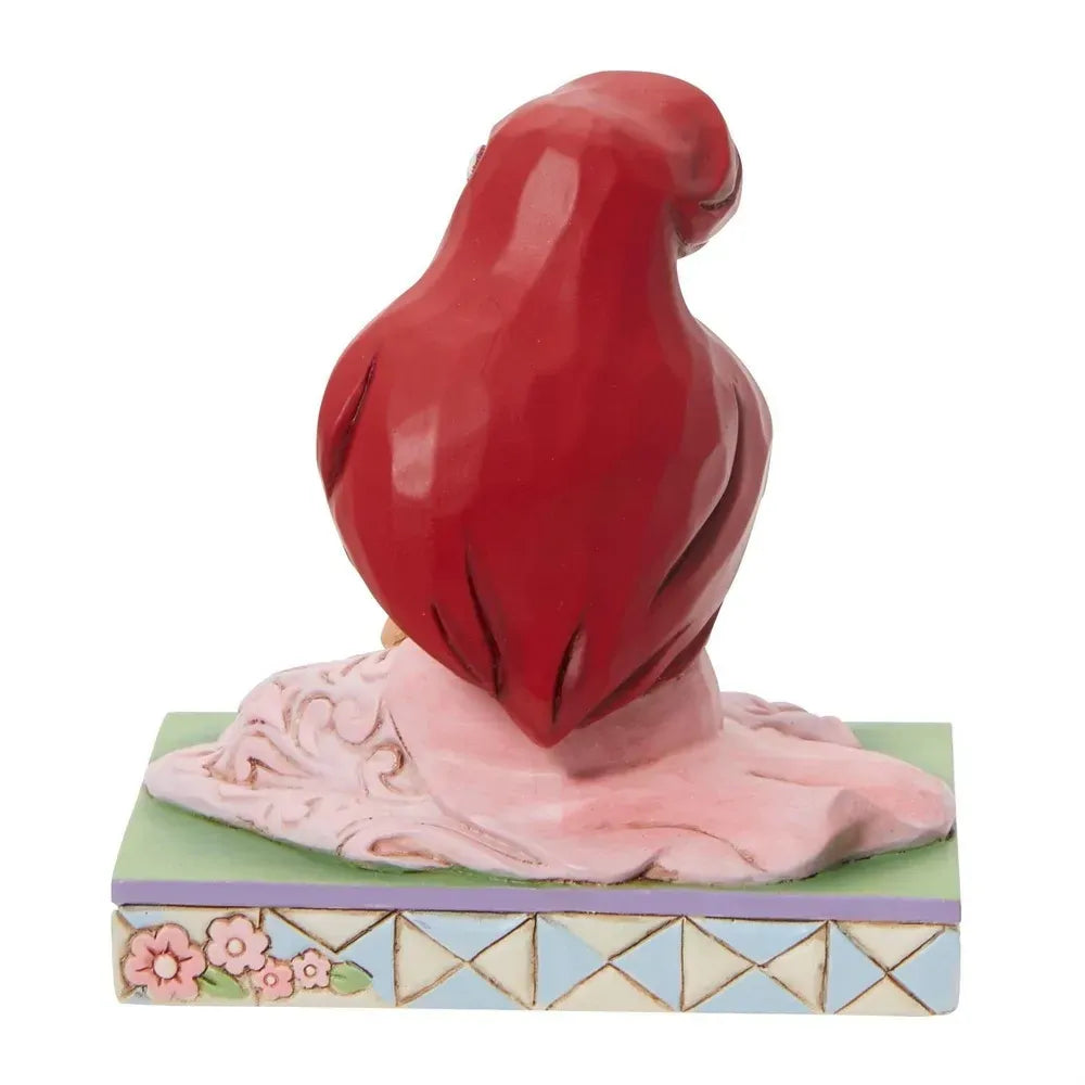 Rear view of Ariel figurine seated in pink gown with scrollwork detail, floral and lattice painted base