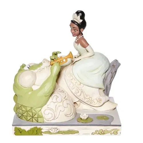 Tiana figurine in white gown holding trumpet, beside Louis the alligator, on carved base with lily pad detail