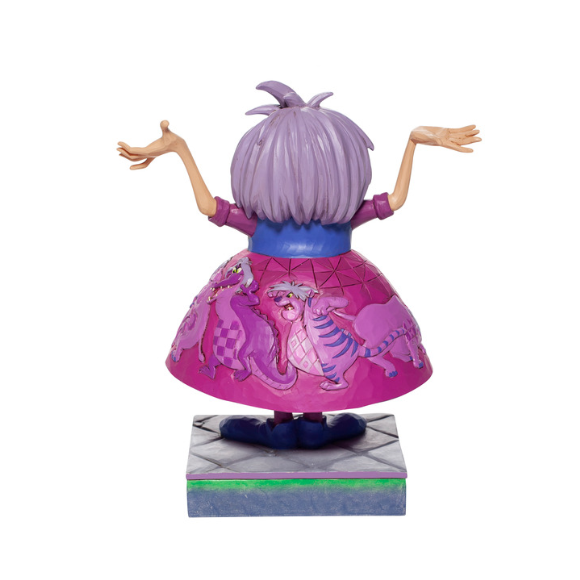 Rear view of Madam Mim figurine showing purple hair and full skirt decorated with painted cat figures, on grey tiled base
