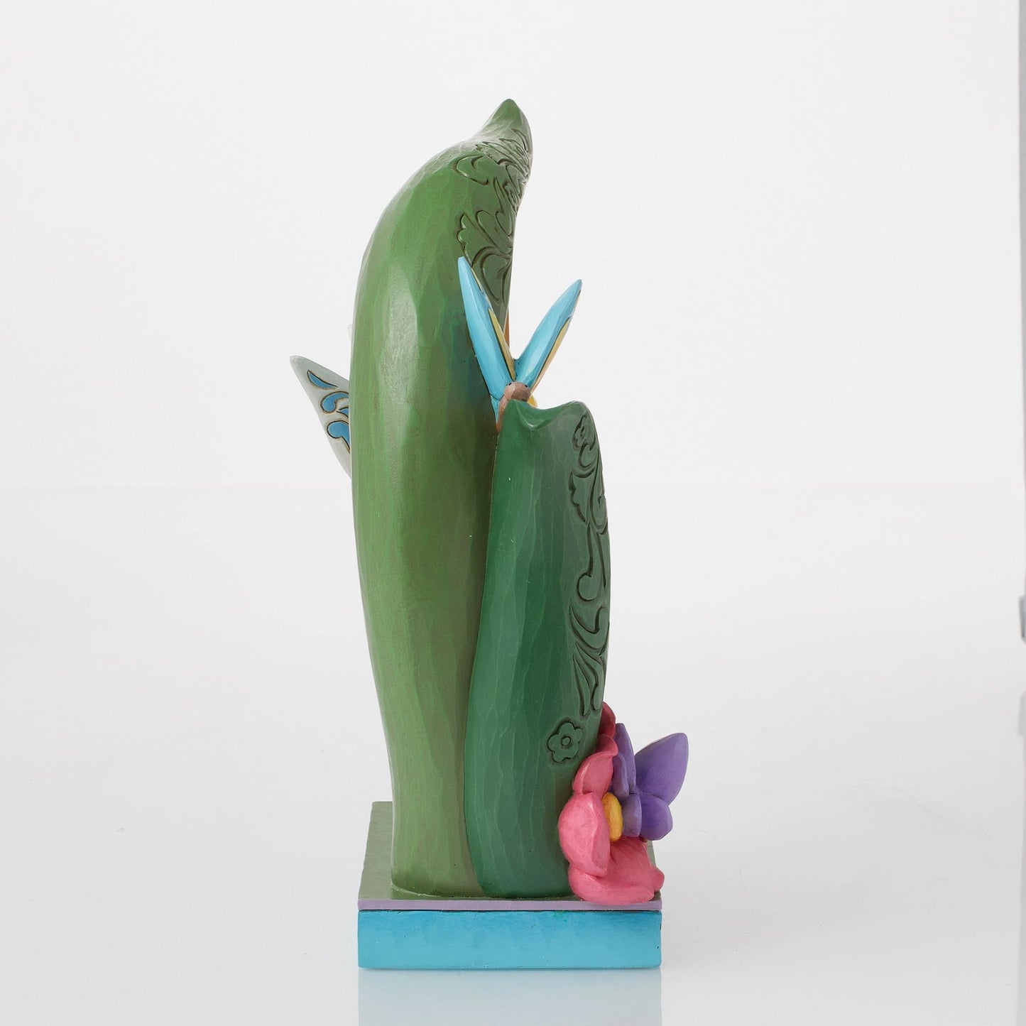 Narrow side view of Tinker Bell figurine showing scrollwork detail on curved green stem, pink flower and butterfly