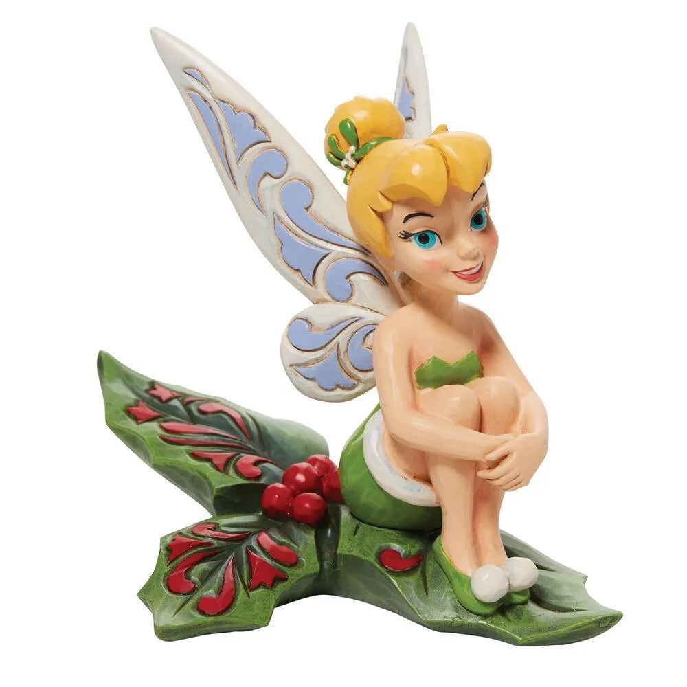 Front view of Tinker Bell figurine seated on a holly leaf base with red berries, scrollwork wings and mistletoe hair detail