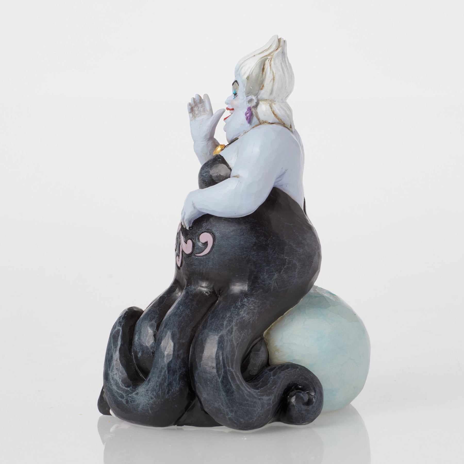 Rear 3/4 view of Ursula figurine with hands raised, black tentacles with pink scrollwork, teal painted base