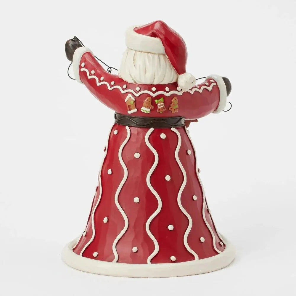 Rear view of Santa figurine showing red robe with white dot and wave detail; gingerbread cookie motifs decorating the upper back
