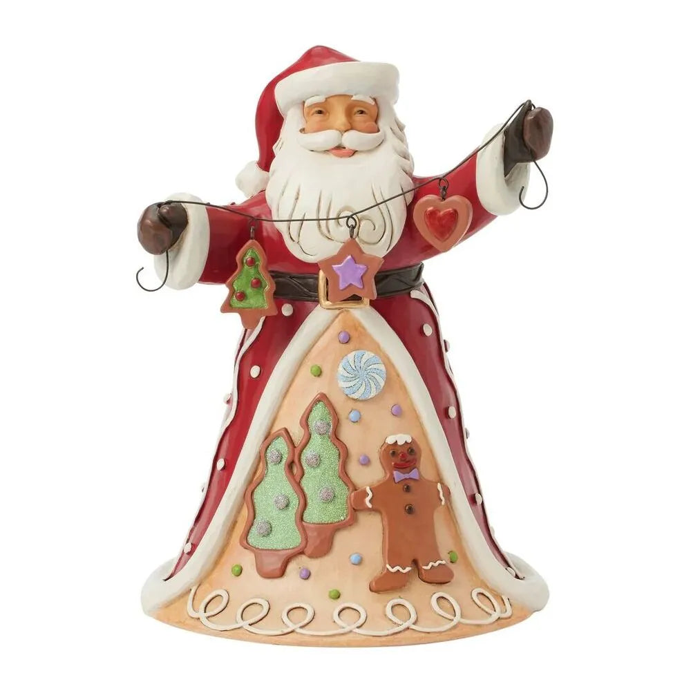 Santa figurine with arms outstretched holding a wire garland of cookie ornaments; robe features gingerbread man, trees, and candy decorations