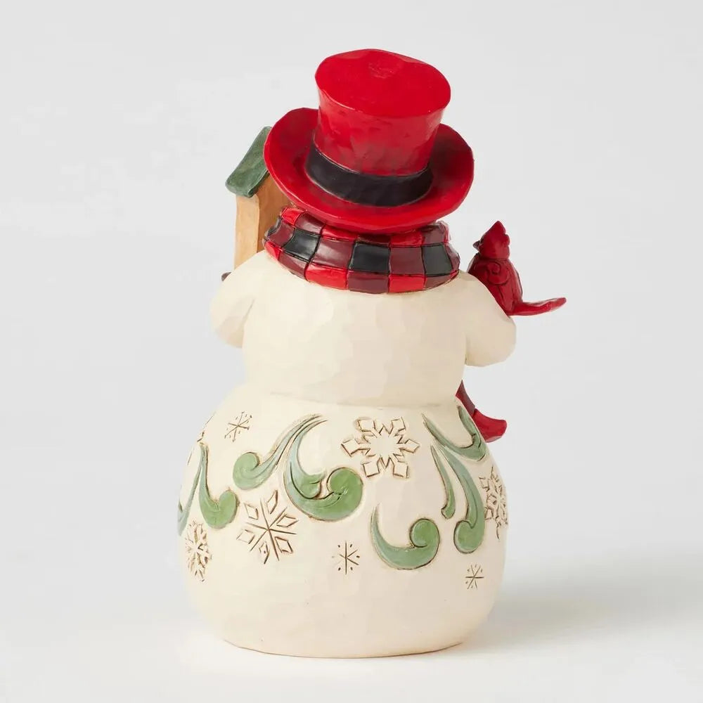 Rear view of a Jim Shore snowman figurine showing a red cardinal, buffalo check scarf, and green scrollwork snowflake body detail