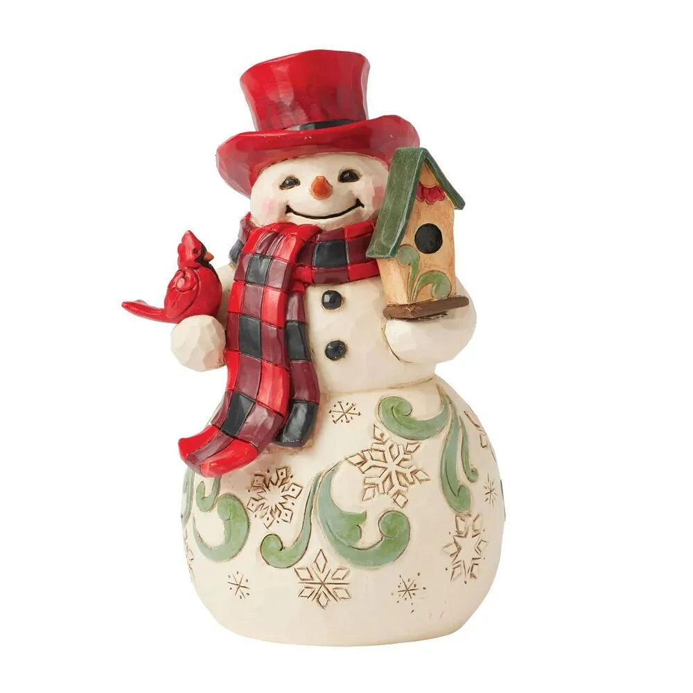 Front view of a Jim Shore snowman figurine in a red top hat holding a cardinal and birdhouse, with green scrollwork snowflake body