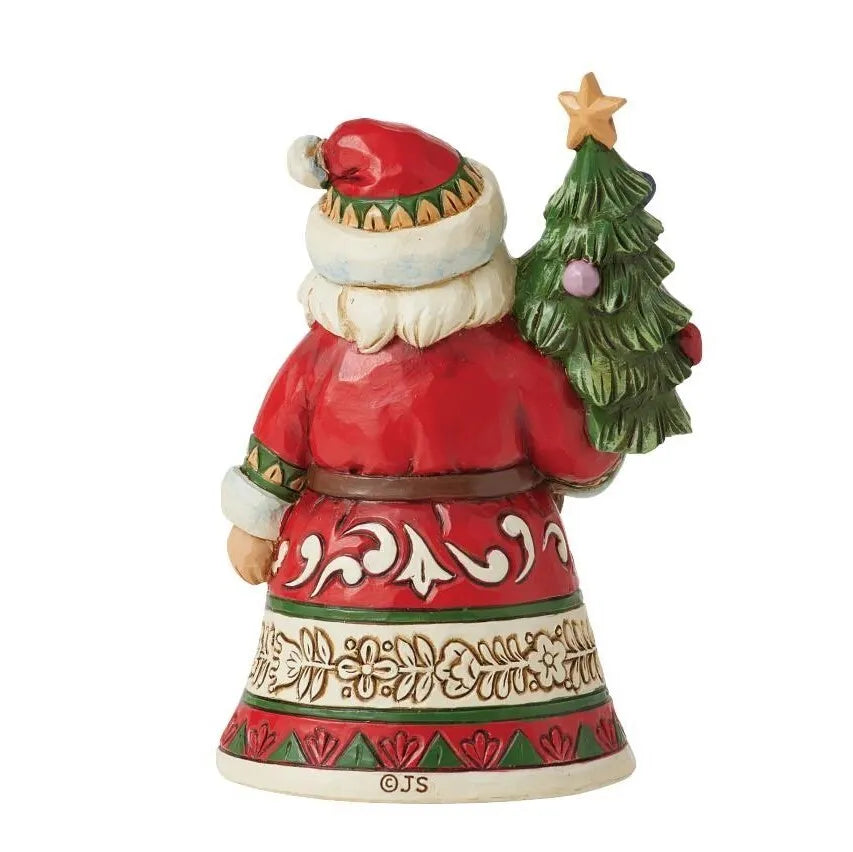 Rear view of a small Santa figurine holding a decorated Christmas tree, scrollwork and holly-banded robe, star tree topper