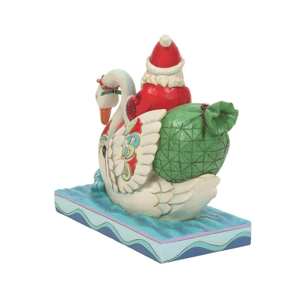 Rear view of Santa figurine on a decorated swan, large patterned green gift sack prominent, scrollwork wings, wave-patterned base