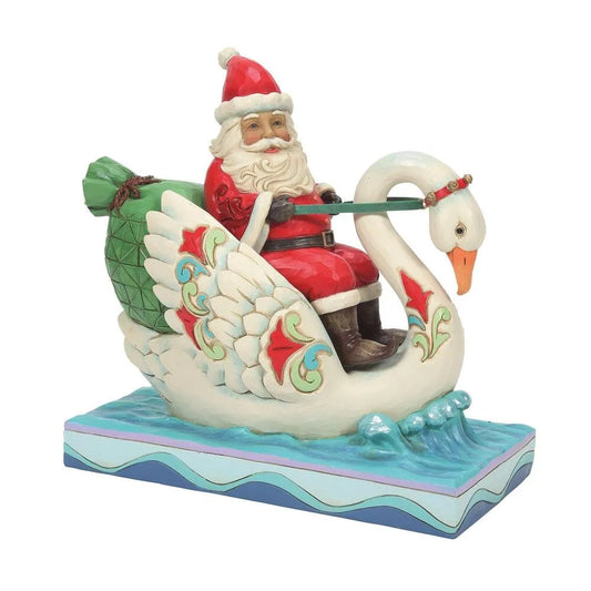 Santa figurine riding a decorated swan on water, large green gift sack on back, scrollwork wing detail, wave-patterned base