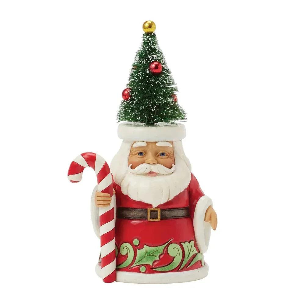 Front view of Santa gnome figurine wearing a bottle brush Christmas tree hat with red ornaments, holding a candy cane, holly-decorated red robe