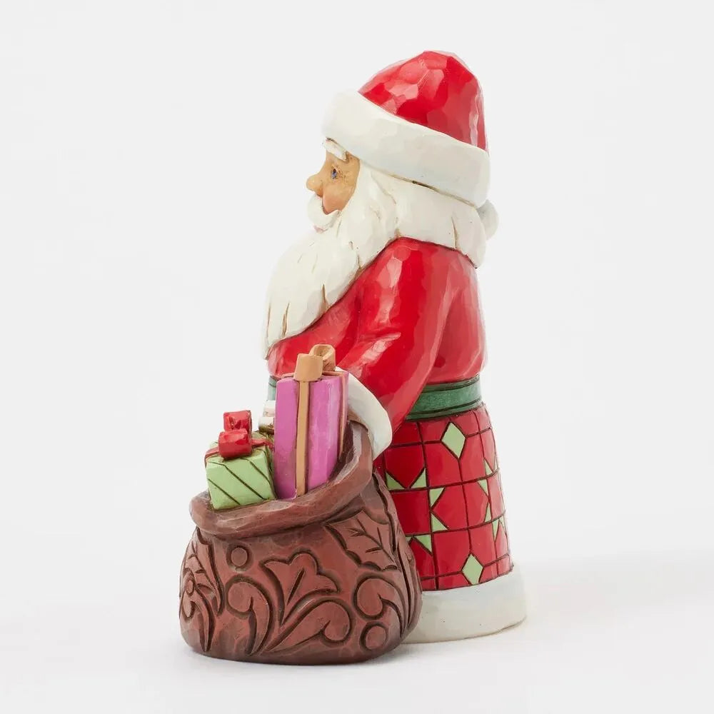 Opposite side view of Santa figurine in geometric patterned robe with green sash, gift-filled scrollwork sack visible behind him