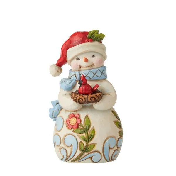 Front view of snowman figurine in red Santa hat with holly, blue scarf, holding a nest with a red cardinal, floral scrollwork body