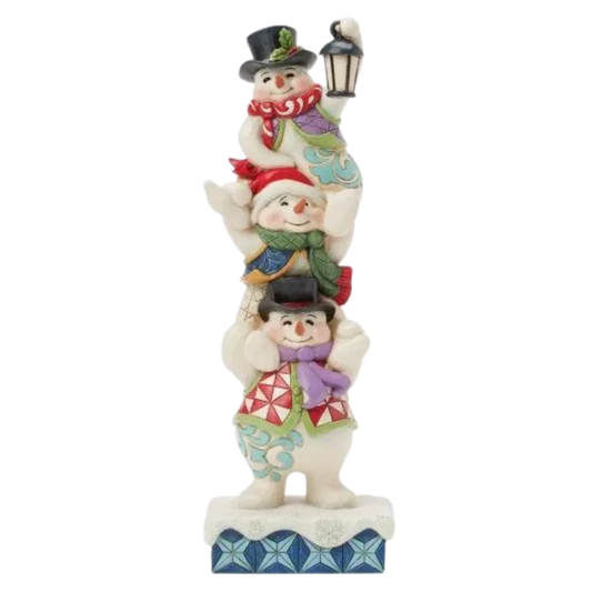 Front view of three Jim Shore snowmen stacked in a tower, each in colourful scarves and hats, the top one holding a lantern