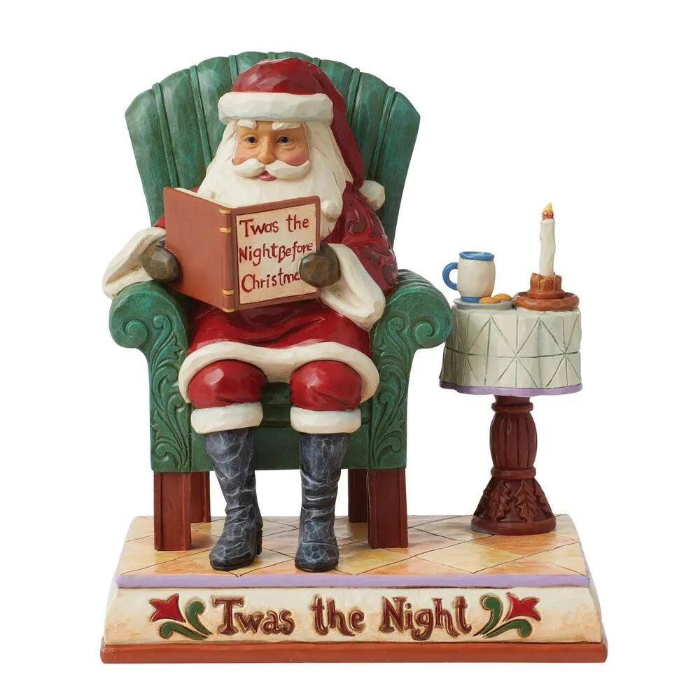 Santa figurine seated in green armchair reading "Twas the Night Before Christmas" book, pedestal table with candle, inscribed base 