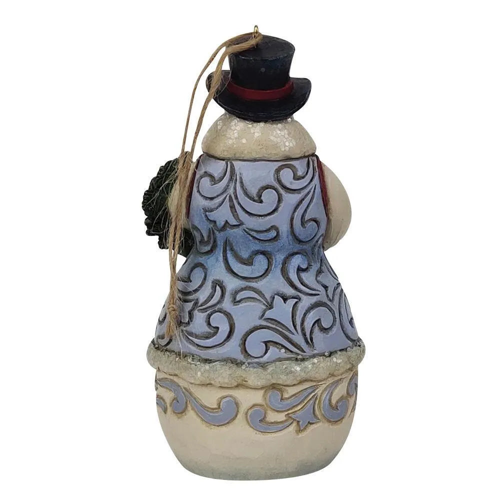 Rear view of a Jim Shore snowman hanging ornament, blue scrollwork coat, black top hat, holding a Christmas wreath