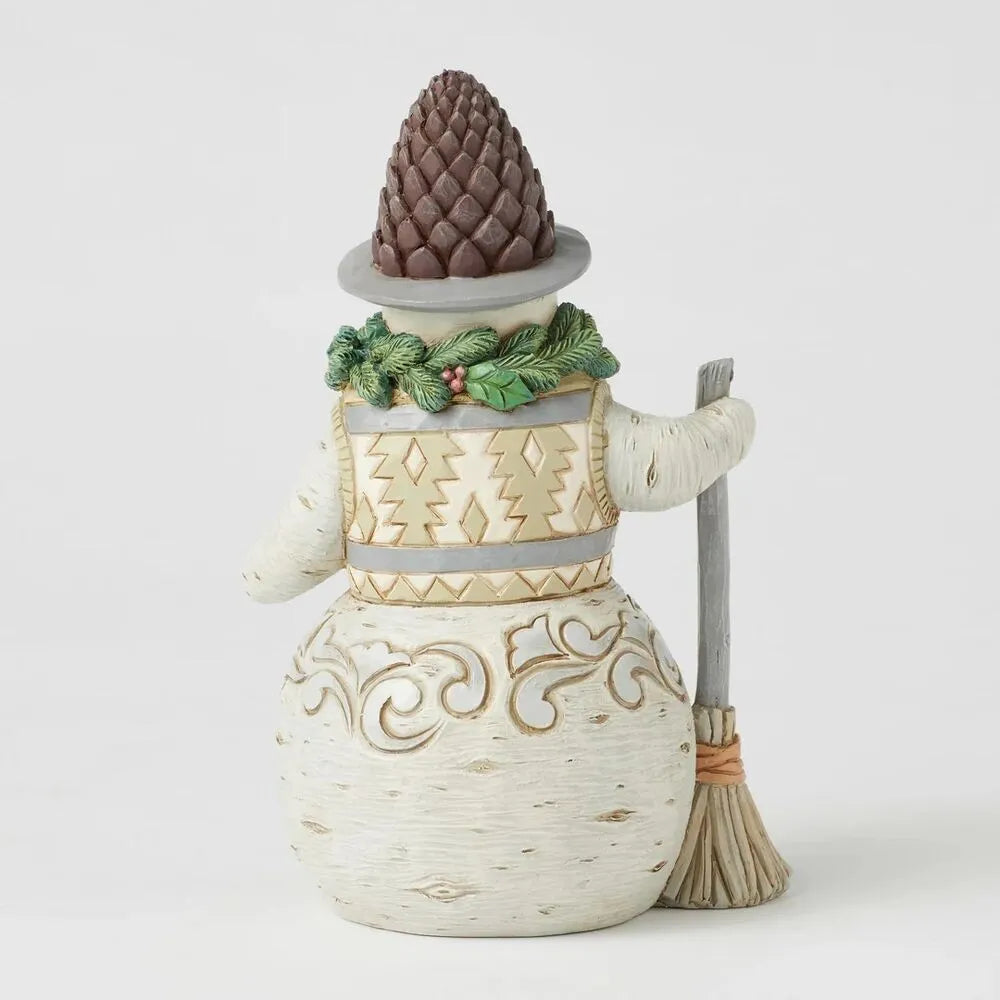 Rear view of woodland snowman figurine with pinecone hat, evergreen and holly wreath collar, gold tree-pattern vest, broom