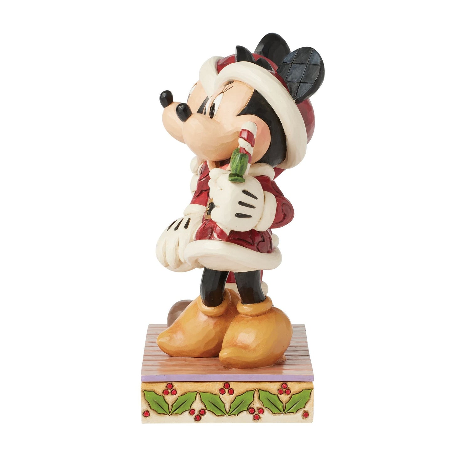 Side view of Jim Shore Minnie Mouse figurine in red Santa outfit holding a candy cane
