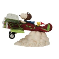 Side view of Jim Shore Snoopy Flying Ace figurine in aviator goggles piloting a biplane
