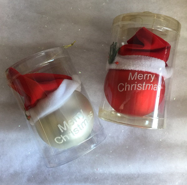 Two Christmas-themed clear plastic cups with Santa hats on a faux snow background.