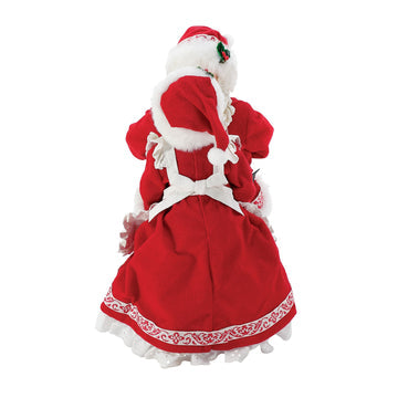 Rear view of Mrs Claus figurine in red dress with white lace trim and matching bonnet
