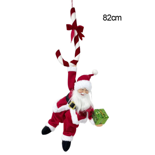 Santa Claus hanging from a red-and-white candy cane with a red bow, holding a green gift