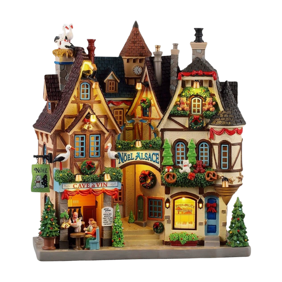 Lit Noël Alsace village building with timber-framed facades, Cave à Vin wine bar, patisserie, stork figurines, and festive wreaths