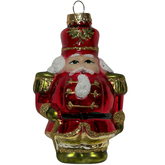 Decorative Christmas ornament of a red-suited figure with gold accents on a white background