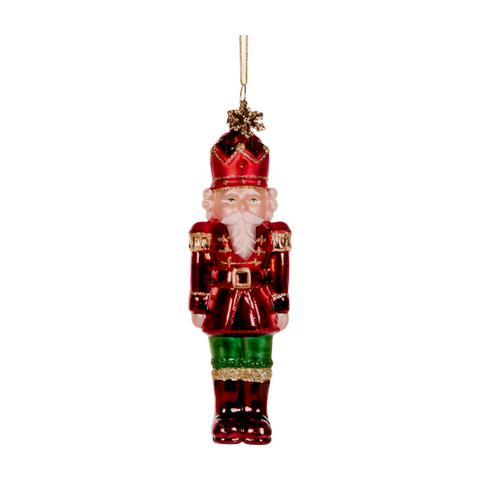 Glass nutcracker decoration in red and green with gold detailing and a golden star on top
