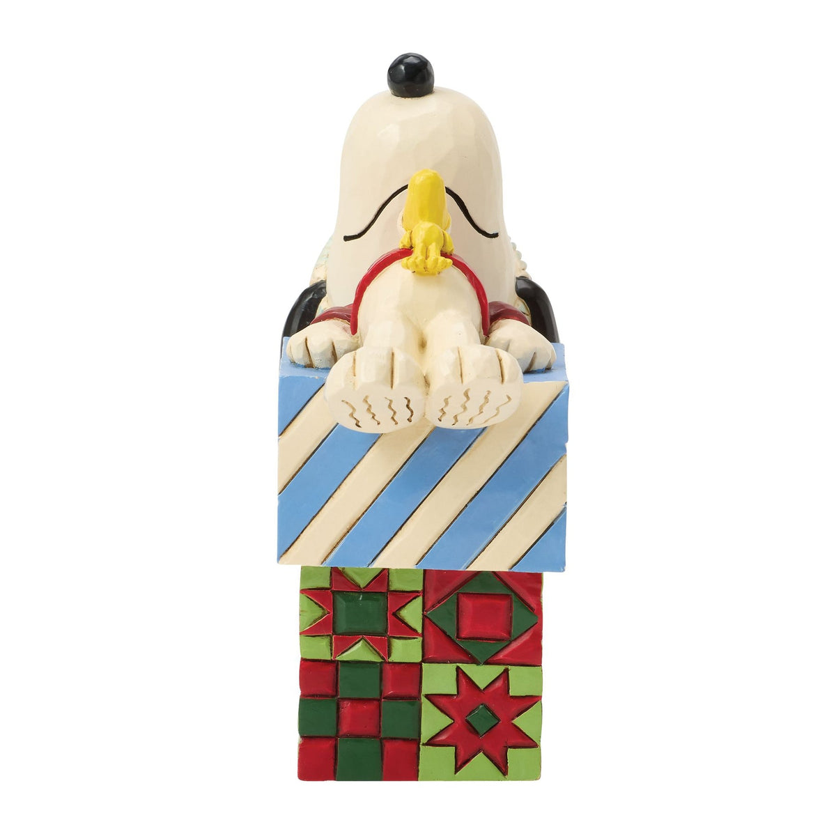 Snoopy and Woodstock Christmas figurine, right front angle, Snoopy draped over blue striped and red quilt-patterned gift boxes 