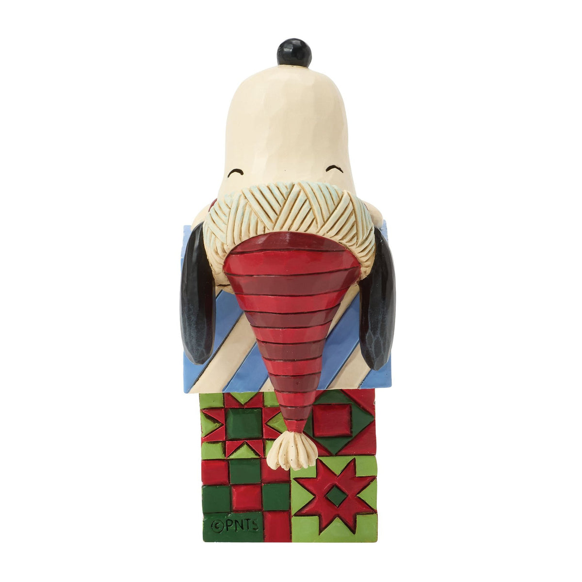 Rear view of Snoopy Christmas figurine showing textured scarf collar, striped red nightcap, and red and green quilt-patterned gift boxes 