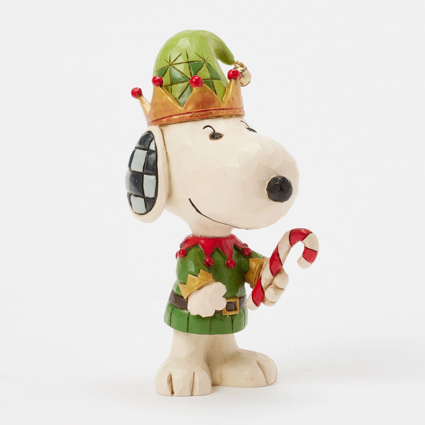 Left profile view Snoopy elf figurine in green and red costume with gold crown-brim hat, red berries, bell, holding candy cane