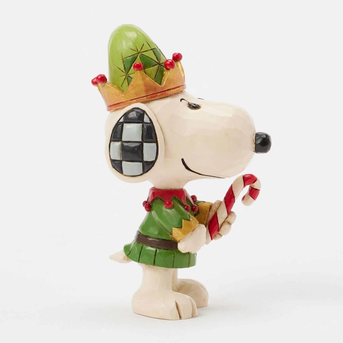 Side profile of Snoopy elf figurine in green and red jester costume with crown-brim hat, checkered ear, holding candy cane