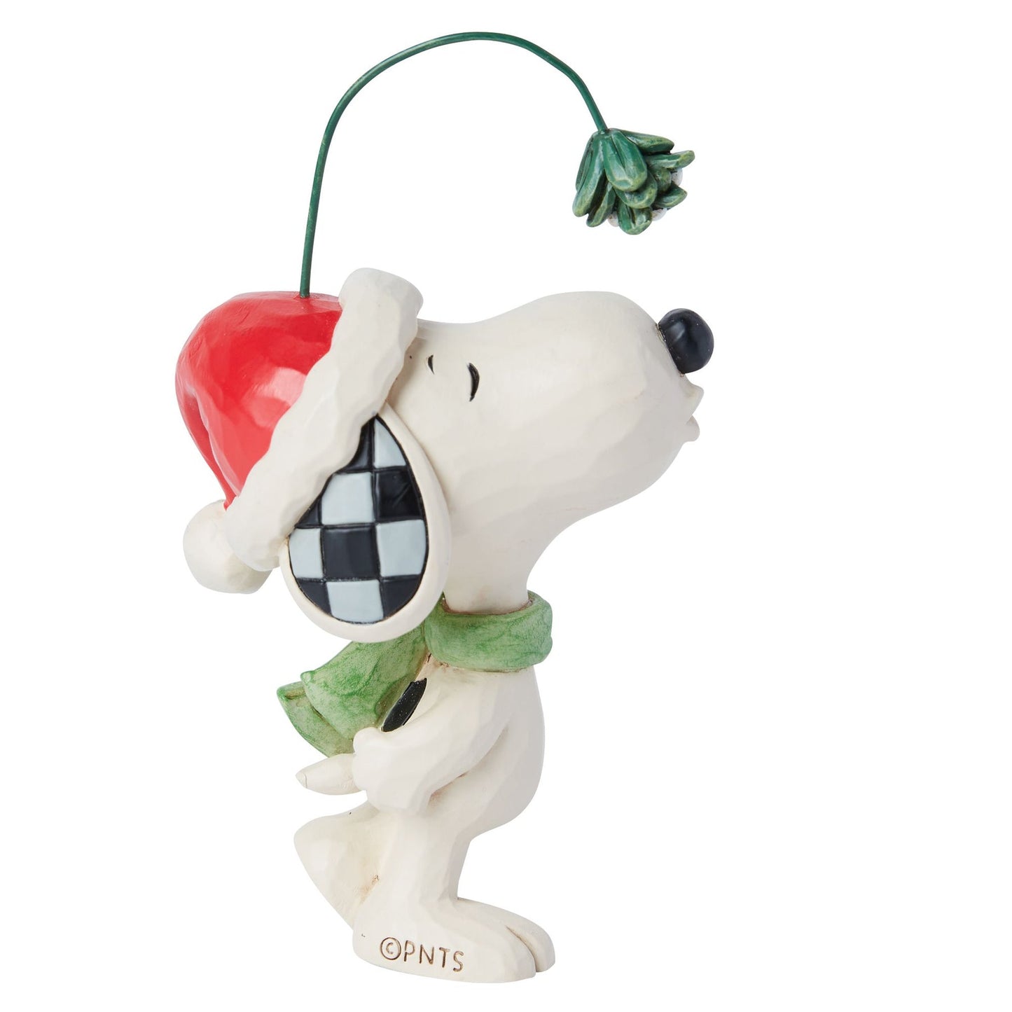 Left side view of Snoopy figurine in Santa hat and green scarf, nose raised toward mistletoe on a wire