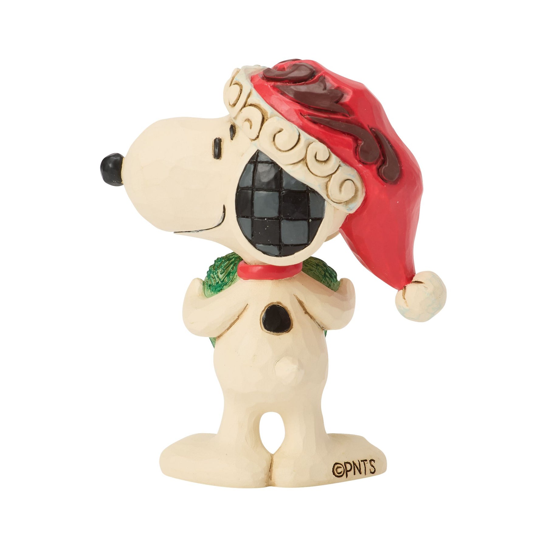 Rear view of Snoopy Christmas figurine showing red folk art Santa hat with scrollwork detail and green heart-shaped wreath 
