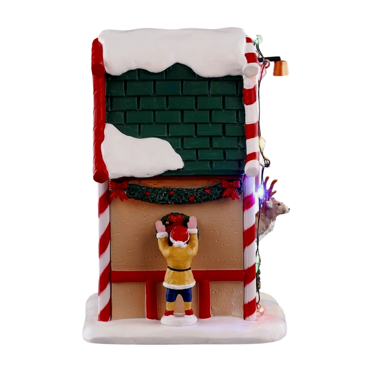 Right view of Prancer's reindeer stable village building with green roof, candy cane columns, garland trim, and elf hanging a wreath
