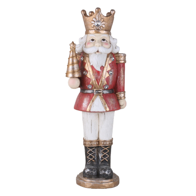 Red and gold nutcracker king holding a golden Christmas tree and wearing a crown