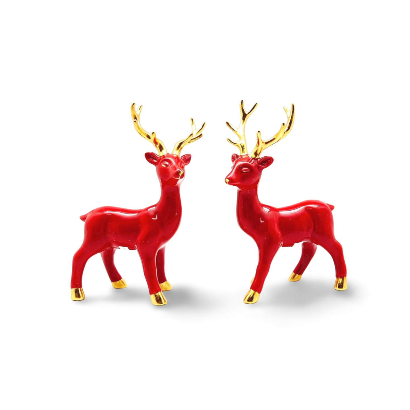 Glossy red ceramic reindeer figurines with gold antlers, hooves, and nose, standing on all fours