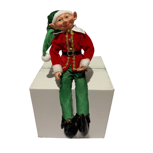 Sitting Christmas elf in red jacket and green trousers with a green hat and black boots
