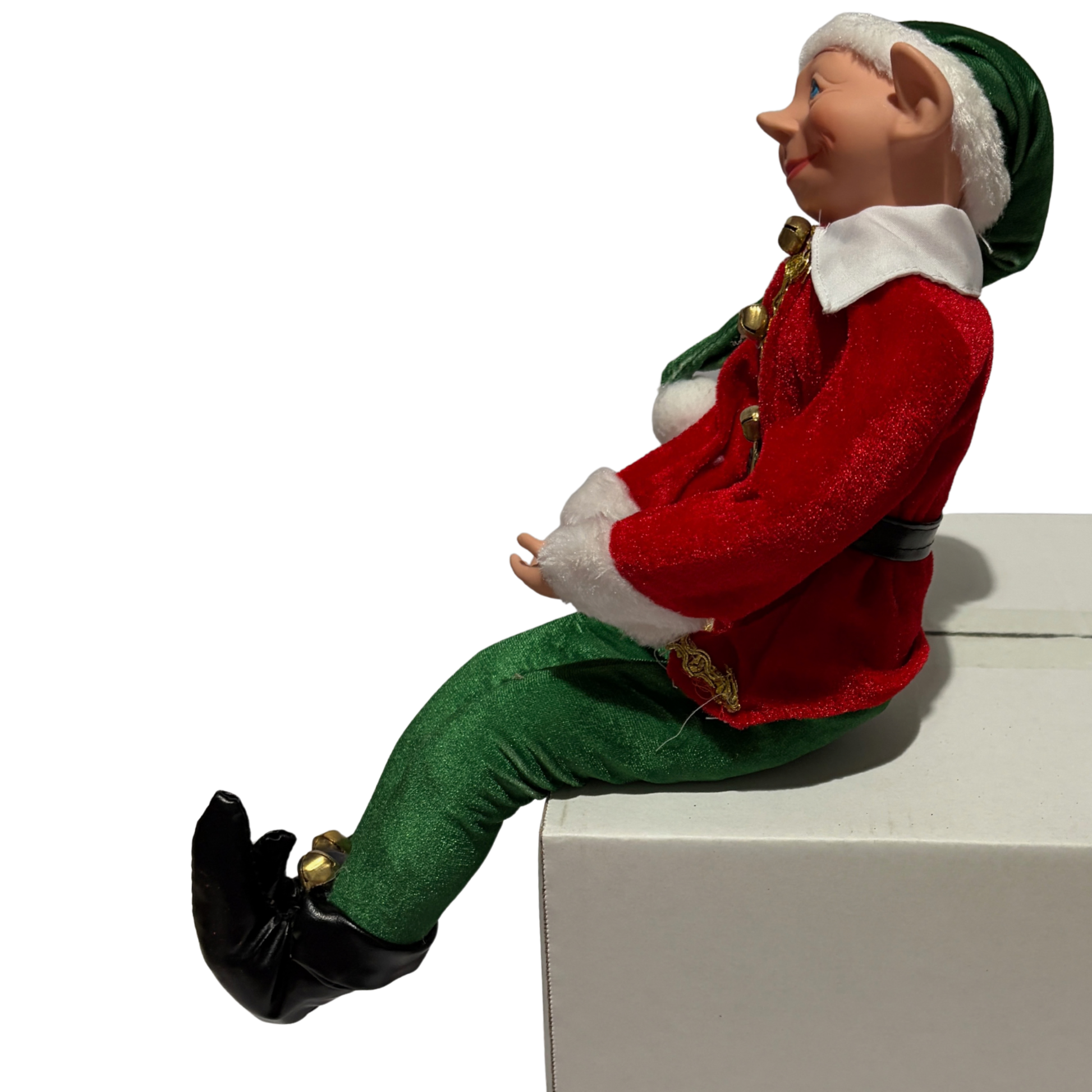 Sitting Christmas elf in red jacket and green trousers with a green hat and black boots