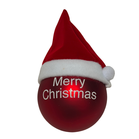 Red Christmas bauble with white “Merry Christmas” text and a small Santa hat on top