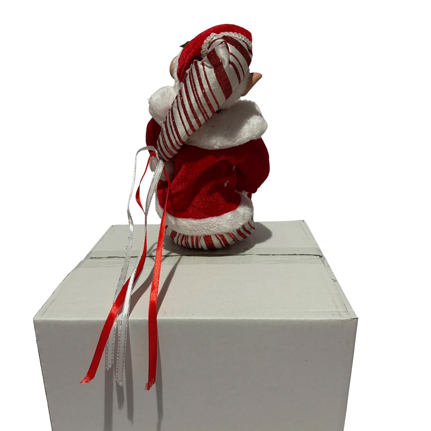 Sitting Christmas elf in red velvet jacket with white fur trim and striped trousers