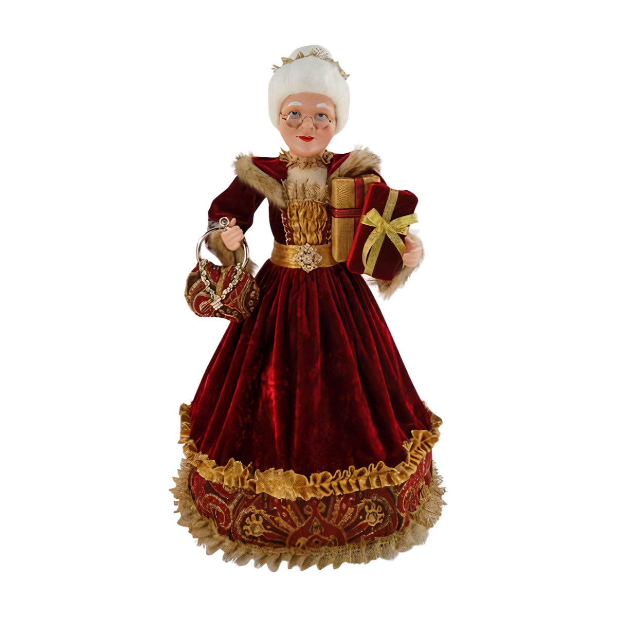 Mrs Claus wears a red velvet gown with gold trim and faux fur accents, holding a gold-wrapped gift and patterned handbag