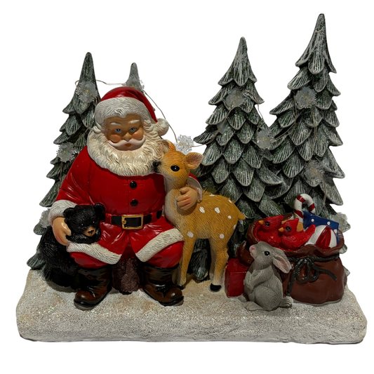 Santa sitting in a snowy forest with deer, rabbit, fox, and bear cub surrounded by pine trees