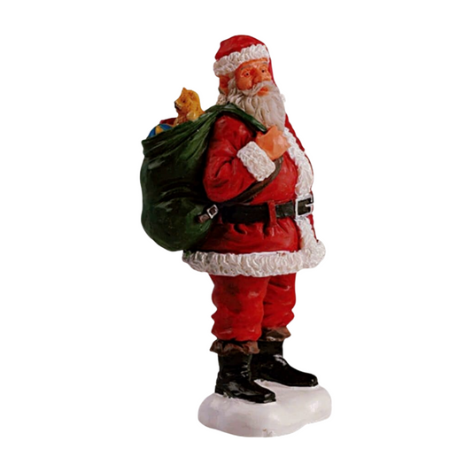 Christmas village figurine of Santa Claus in red suit carrying a large green gift sack filled with toys, on a snowy white base