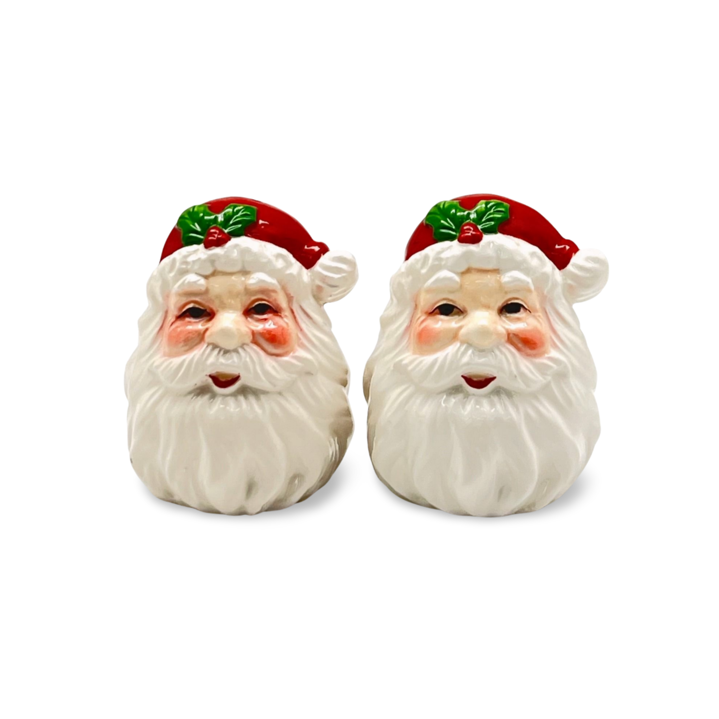 Pair of ceramic salt and pepper shakers shaped like Santa Claus heads with red hats, holly leaves, and white beards.