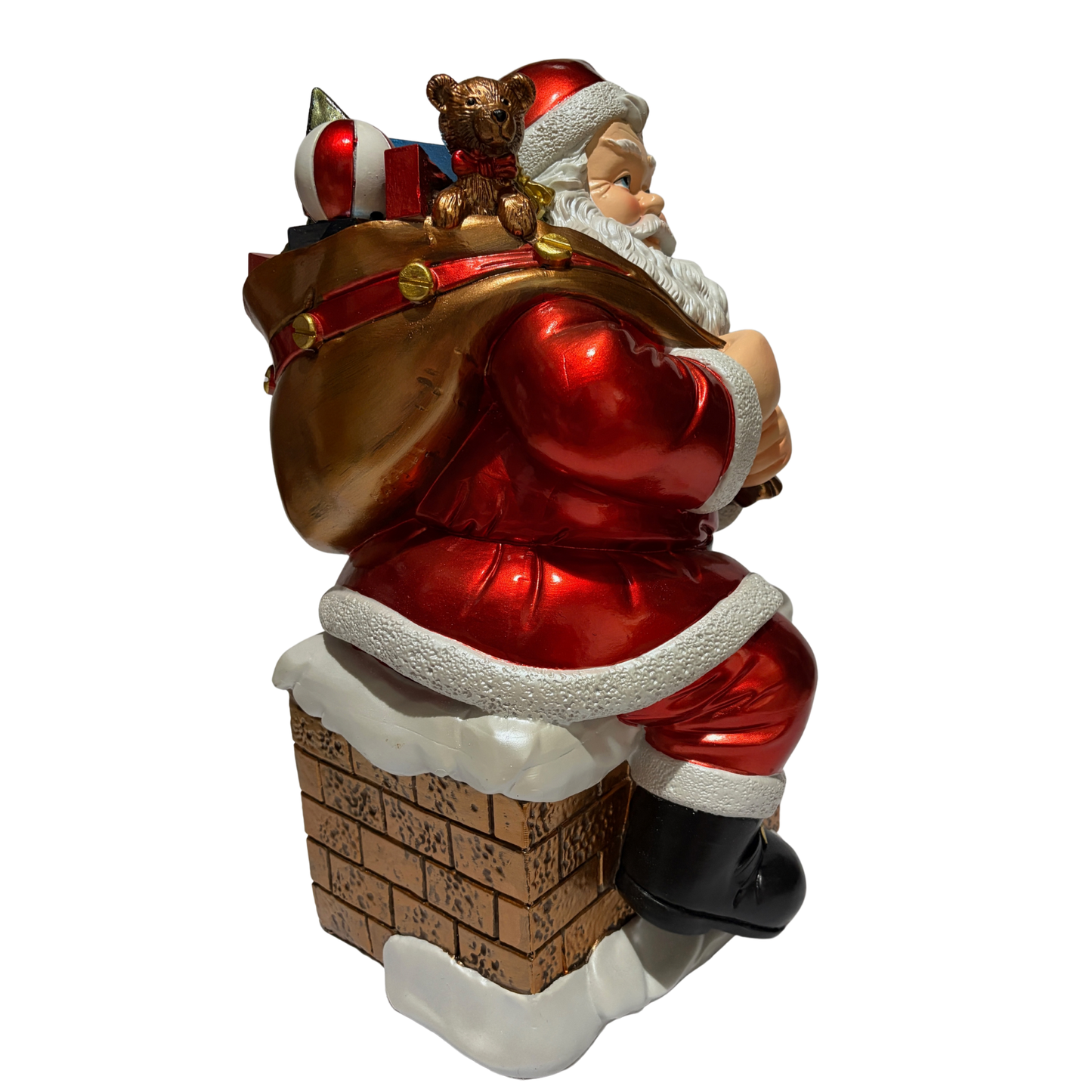 Santa ornament sitting on a snow-covered chimney holding a sack of toys