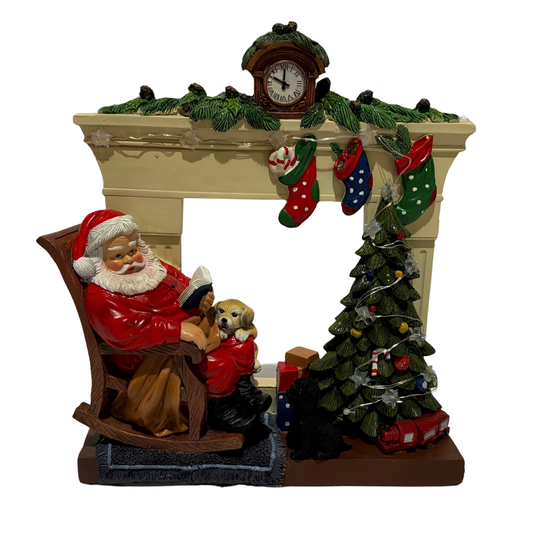 Santa sitting in a rocking chair beside a Christmas tree and fireplace with stockings and a puppy on his lap