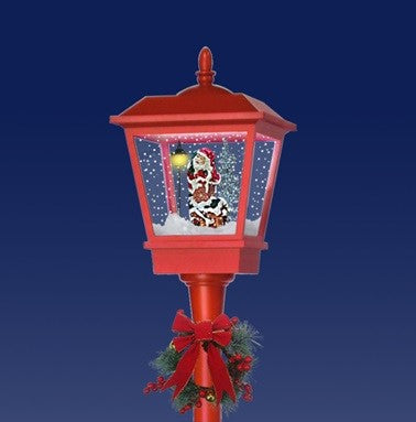 Close-up of red musical lamp post lantern with Santa snow effect scene and festive wreath detail