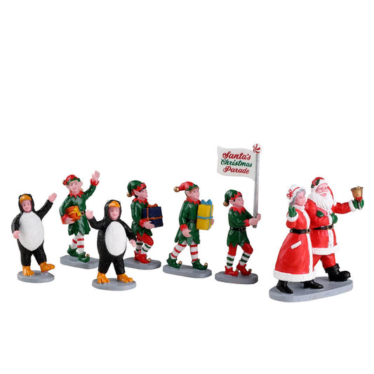 Rear view of Lemax Santa's Christmas Parade figures with Santa, Mrs Claus, elves and penguin costumes