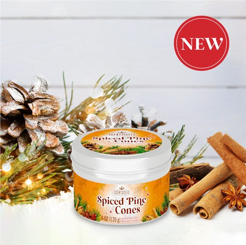 Jar of 'Spiced Pine Cones' candle with Christmas decorations on a white background